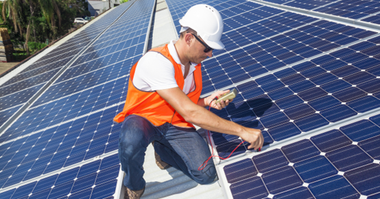 An Australian mechanic installing solar panels on rooftop.png